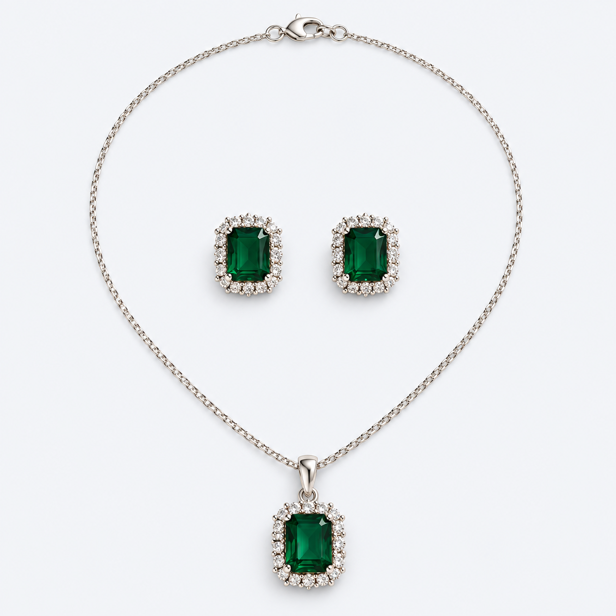 Conjunto de colar e brincos prateados com pedras verdes sobre fundo claro
